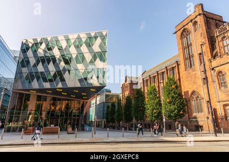 Contrast of old and new buildings on Deansgate in Manchester with historic John Rylands Research Institute and Library. Stock Photo