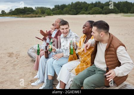 Diverse group of friends camping on beach in Autumn and having fun together outdoors Stock Photo