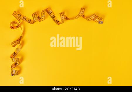 Tape measure on yellow background Stock Photo