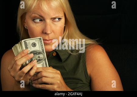 Attractive Woman Gets Greedy About Her Stack of Money Stock Photo