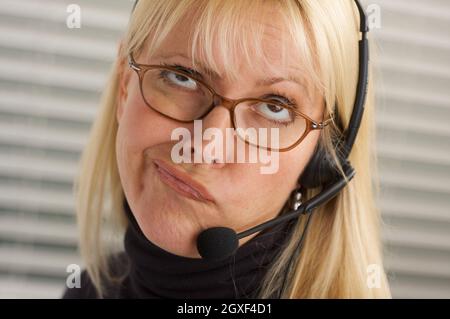 Goofy businesswoman talks on her phone headset. Stock Photo
