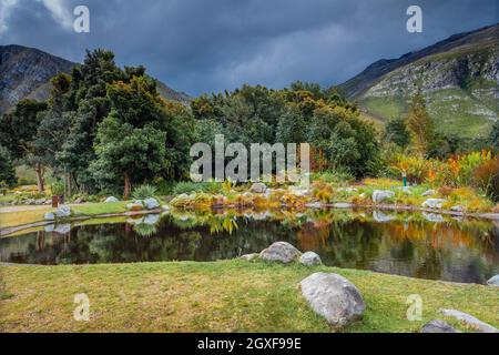 Landscape of Beautiful Lake over Majestic Mountains Covered with Fresh Greenery Background. Harold Porter National Botanical Garden. South Africa. Stock Photo