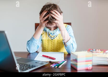 Stressed pupil in despair because schools are still closed due to Coronavirus Stock Photo