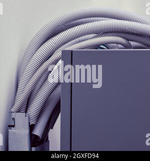 Electric cables and wires in white plastic corrugation, close up Stock Photo