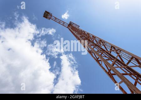 Construction crane against blue sky, bottom view. Stock Photo