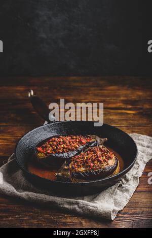 Eggplants stuffed with ground beef, tomatoes and spices in frying pan. Traditional dish Karniyarik of turkish cuisine Stock Photo