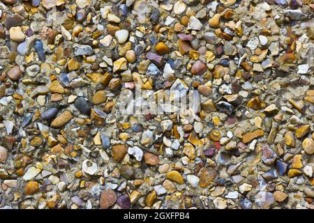 A rough pebble dash covering on an external wall showing small stones of various shapes and colours Stock Photo