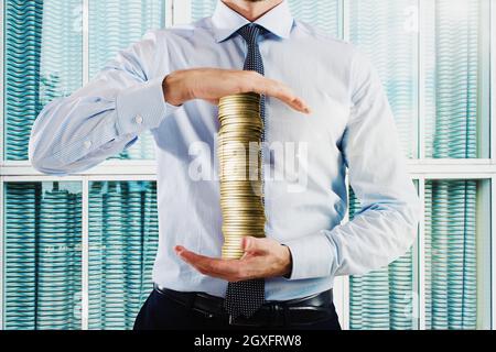 Businessman holds in his hands a stack of coins Stock Photo