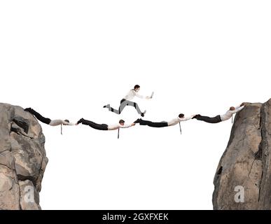 Businessmen working together to form a bridge between two mountains Stock Photo