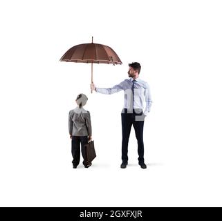 Businessman with umbrella that protect a child. Concept of young economy and startup company protection Stock Photo