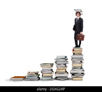Scale with books and man with graduation hat Stock Photo