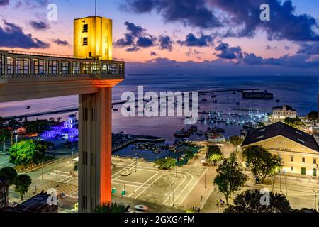 Lacerda elevator illuminated at dusk and with the sea and boats in the background in the city of Salvador, Bahia Stock Photo