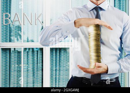 Businessman holds in his hands a stack of coins Stock Photo