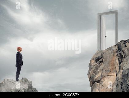 Businessman thinks about how to get to a door. concept of ambition in business Stock Photo