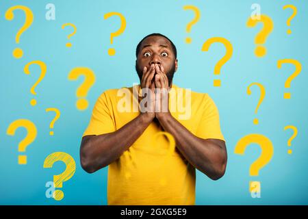 Amazed and shocked expression of a black boy over cyan background Stock Photo