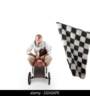 Businessman with bag in a small car goes at the arrival of a race isolated on white background Stock Photo