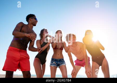 Group of happy friends playing at beach volley at the beach Stock Photo