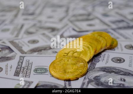 Gold bitcoin coins cryptocurrency on the group of money 100 USD dollars Stock Photo