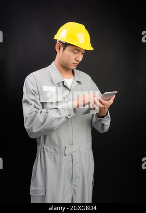 Handsome happy supervisor or technician worker with digital tablet on black background Stock Photo