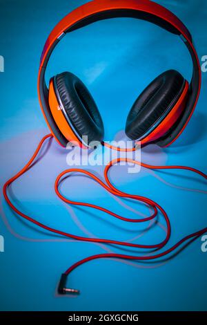 Closeup Photo of a Big Red Headphones on the Table. Stylish Accessory for Dj. Music Fan. Equipment for a Home Schooling. Photo with Copy Space. Stock Photo