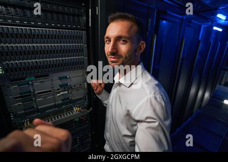 Bearded man technician working with it equipments in server farm Stock Photo