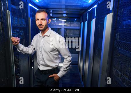 Bearded handsome maintenance administrator working with tech it equipments in data center Stock Photo