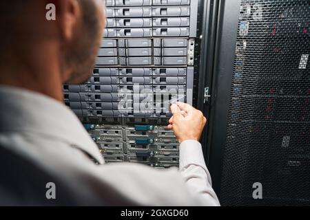 Unrecognized European maintenance administrator examining supercomputer in serber room Stock Photo