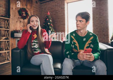 Photo portrait young couple spending time together on sofa using smartphones indoors apartment Stock Photo
