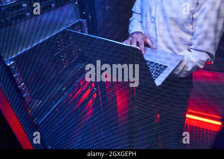 Maintenance engineer in white shirt is examining work of supercomputer in server room Stock Photo