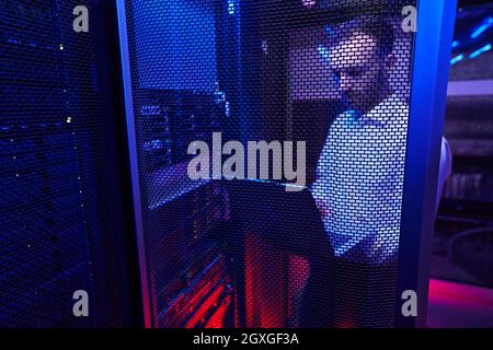 Bearded Caucasian programmer finding and troubleshooting computer server in data center Stock Photo