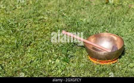 Metal singing bowls in the grass of the own garden, zen Stock Photo