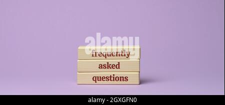 inscription frequently asked questions on wooden blocks on a purple background. QA concept, help and tips Stock Photo
