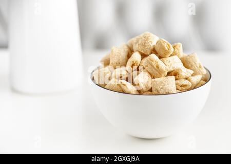 Dry breakfast cereal pads with milk on a light table. selective focus. The concept of healthy, dietary breakfasts. Stock Photo