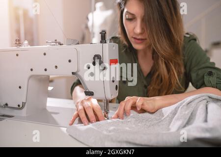 Seamstress works to new clothes ordered by online order Stock Photo