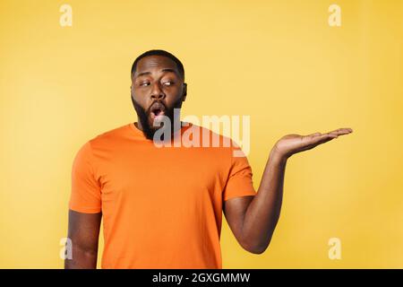 Surprised black man holds something in hand. Stock Photo