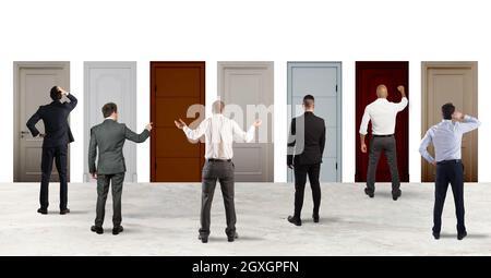 Business people looking to select the right door in which to enter. Concept of confusion and competition Stock Photo