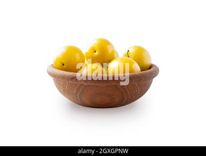 Heap of plums isolated on white background. Yellow plums with copy space for text. Plums in wooden bowl on white background. Fresh summer fruits. Stock Photo