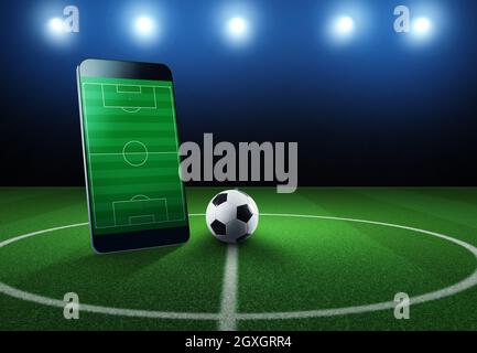 Cellphone and ball on a soccer field Stock Photo