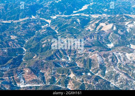 Flight over the mountain hills . Aerial view of mountains covered by forest . Highlands of Switzerland Stock Photo