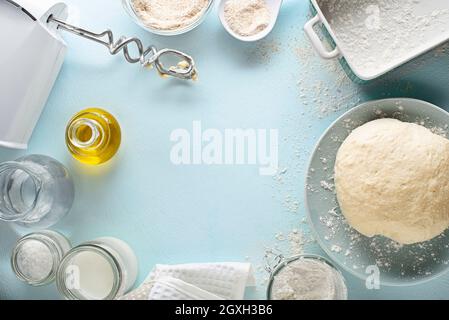 Ingredients for making and baking homemade bread on blue table background. Mixing and kneading the dough Stock Photo