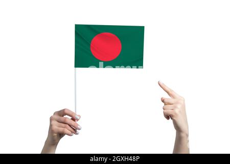 A beautiful female hand holds a Bangladesh flag to which she shows the finger of her other hand, isolated on white background. Stock Photo