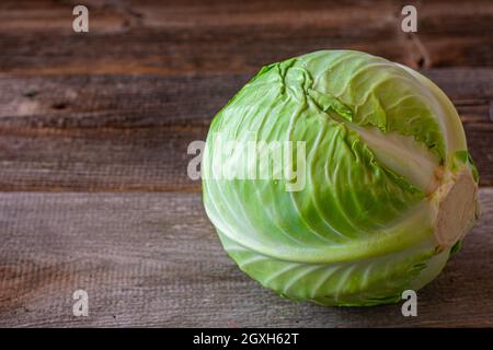 Whole Cabbage head isolated on wooden background. Side view with copy space Stock Photo