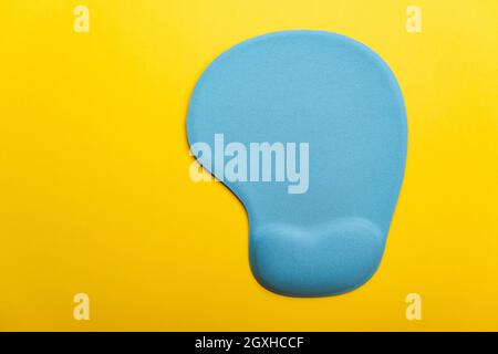 Top view flat lay of blue pad or mousepad for computer mouse modern design isolated on a yellow background and copy space Stock Photo