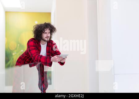 young freelancer in bathrobe working from home using tablet computer Stock Photo