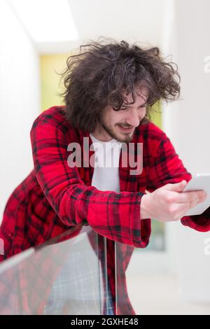 young freelancer in bathrobe working from home using tablet computer Stock Photo