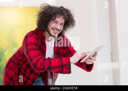 young freelancer in bathrobe working from home using tablet computer Stock Photo