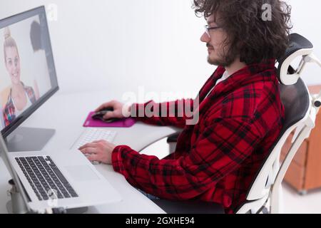 young graphic designer in bathrobe working at home office using computer Stock Photo