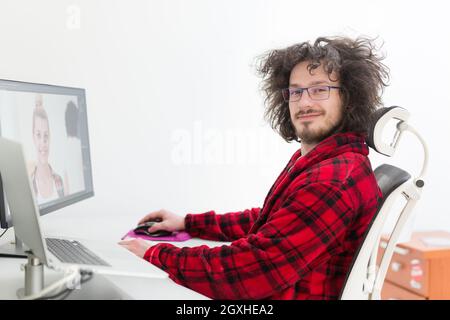 young graphic designer in bathrobe working at home office using computer Stock Photo