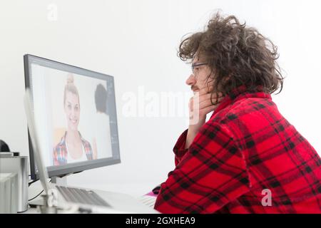 young graphic designer in bathrobe working at home office using computer Stock Photo
