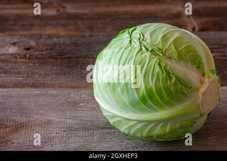 Whole cabbage isolated on wooden table. Closeup and side view Stock Photo